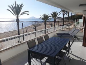 a balcony with a table and chairs and the beach at Jormar in Port de Pollensa