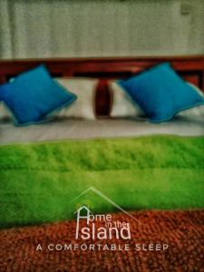 坦加拉的住宿－Home in the Island，一张带两个蓝色枕头的床的画