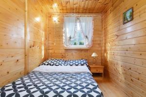 a bedroom with a bed in a wooden cabin at holiday home in Domyslow by Kolczewo the perfect place for two guests in Kołczewo