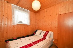a bed in a wooden room with a window at Holiday resort, Wicie in Wicie
