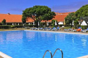 a large swimming pool with chairs and a building at Holiday resort Clube Pinhal da Foz, Esposende, Studio for 2 pers in Esposende