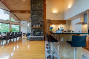 a kitchen and dining room with a stone fireplace at Starchase by H2 Life in Niseko