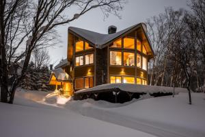 a large house in the snow at night at Starchase by H2 Life in Niseko