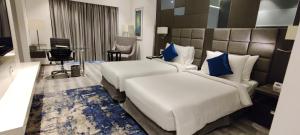 Pokój hotelowy z 2 łóżkami i biurkiem w obiekcie Best Western Plus Tejvivaan w mieście Visakhapatnam