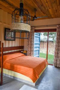 a bedroom with a bed and a chandelier at Tree of Life Ecotainers Agra in Agra