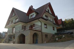 a house with a gambrel roof on top of it at Pokoje Gościnne U Siyły in Bukowina Tatrzańska