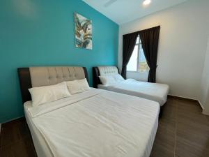 two beds in a bedroom with a blue wall at Golden Hill Home by Dreamscape in Cameron Highlands