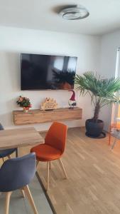 sala de estar con TV de pantalla plana en la pared en Moderne, barrierefreie Ferienwohnung en Plauen