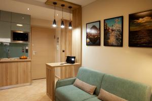 塞萨洛尼基Designer apartments close to the center + free parking的客厅配有沙发和笔记本电脑(书桌)