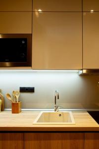 uma cozinha com um lavatório e um micro-ondas em Designer apartments close to the center + free parking em Tessalônica