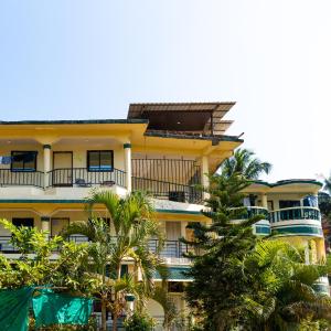 Un edificio amarillo con palmeras delante. en IVON Guest House Arambol, en Arambol 20 fotos más