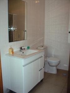 a white bathroom with a sink and a toilet at Casa do Mosteiro de Refoios do Lima in Ponte de Lima