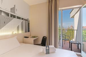 a hotel room with a bed and a balcony at B&B Hotel Firenze City Center in Florence