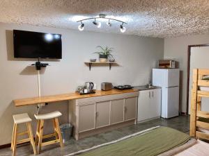 a small kitchen with a counter and a refrigerator at Aloe Cottage in Nelspruit