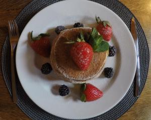 a plate of pancakes with strawberries and berries on it at Liptov Lodge in Liptovský Mikuláš