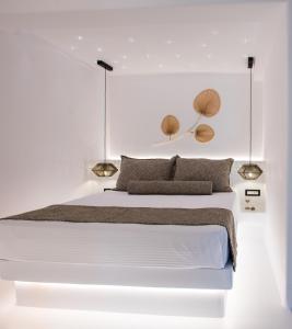 ein weißes Schlafzimmer mit einem großen weißen Bett mit zwei Lichtern in der Unterkunft Case di Venia in Agia Anna