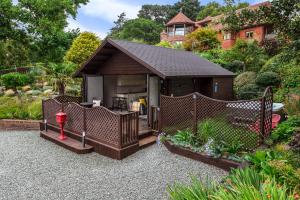 a small cabin with a red fire hydrant in a garden at Hamble Retreat Studios and Lodge in Warsash