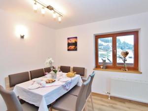 a dining room with a table and chairs and a window at Cozy apartment with mountain views in Wald im Pinzgau