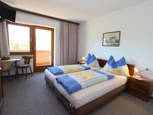 マイスホーフェンにあるSpacious Apartment near Ski Trail in Maishofenのベッド、テーブル、窓が備わる客室です。