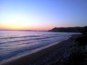 a sunset on a beach with the ocean at PORTO-FINO in Arillas