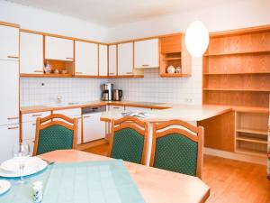 a kitchen with wooden cabinets and a table and chairs at Scenic Apartment in Rattenberg near Reintaler See Lake in Rattenberg