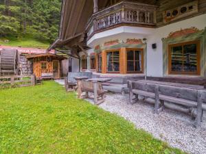 un grupo de bancos sentados fuera de un edificio en Quaint alpine hut in the Stubaital with sauna, en Neustift im Stubaital