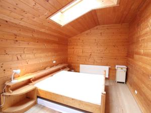 Habitación de madera con cama y tragaluz en Farmhouse with views over the valley en Rauris