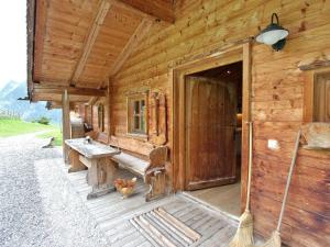 a wooden cabin with a bench and a door at Farmhouse with views over the valley in Rauris