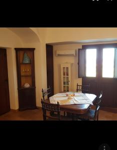 una sala da pranzo con tavolo, sedie e finestra di IL VIGNETO a Pantelleria