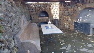 Habitación de piedra con mesa y fogones en IL VIGNETO en Pantelleria