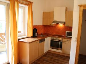 a kitchen with a sink and a stove top oven at Spacious Apartment in GroBarl with Sauna in Grossarl