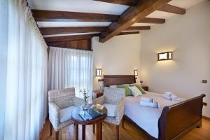 1 dormitorio con 1 cama con sillas y mesa en La Quintana de Somao, Casa de Abajo en Somado