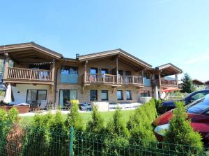 a large house with cars parked in front of it at Apartment in Piesendorf in ski area with sauna in Piesendorf