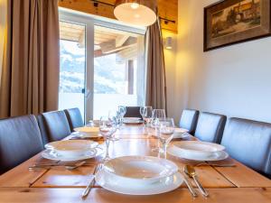 una mesa de madera con platos y copas de vino. en Apartment in Piesendorf in ski area with sauna, en Piesendorf