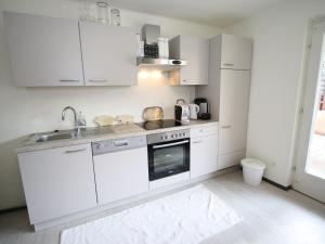 a kitchen with white cabinets and a sink at Apartment near the ski area in Sankt Michael im Lungau
