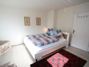 a bedroom with a white bed with a red rug at Apartment near the ski area in Sankt Michael im Lungau