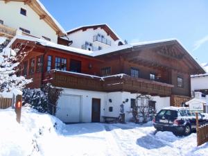 KaunerbergにあるSunny Mountain View Apartment in Kaunerbergの雪に停められた車を持つ家