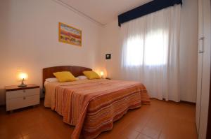 ビビオーネにあるAppartamenti Narcisiのベッドルーム1室(黄色い枕のベッド1台、窓付)