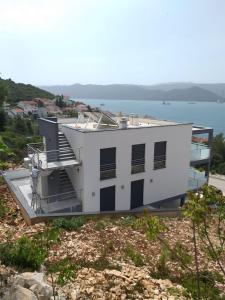 a white house with the ocean in the background at Villa Sun&Sea in Komarna