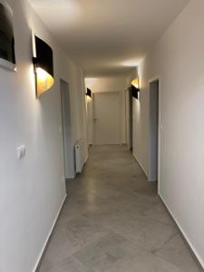 un pasillo con paredes blancas y un pasillo con puertas blancas en WBR. vendégház en Villány