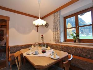 een eetkamer met een houten tafel en een raam bij Serene Cottage in Neukirchen am Gro venediger in Neukirchen am Großvenediger