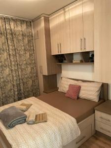 a small bedroom with a bed and cabinets at Apartman SIMS in Bijeljina