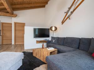 a living room with a couch and a tv at Sunny holiday home with sauna in Piesendorf in Piesendorf