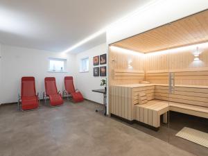 una sauna con sillas rojas en una habitación en Chalet with garden in Bad Hofgastein Salzburg, en Bad Hofgastein