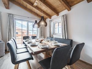 a dining room with a wooden table and chairs at Sunny holiday home with sauna in Piesendorf in Piesendorf
