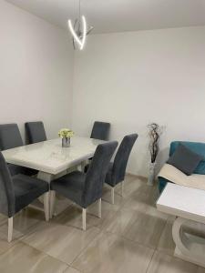 a dining room with a white table and chairs at Apartman SIMS in Bijeljina