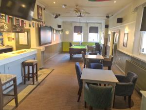 a restaurant with tables and chairs and a pool table at The Swan Hotel in Milton Keynes