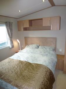 1 dormitorio con cama y ventana en Bude Coastal Lodge en Bude