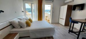 een kamer met een bed en een groot raam bij Guest House Galeb in Supetarska Draga
