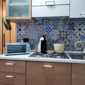 a kitchen with a microwave and a stove top oven at MAISON PLATONE in Alessandria
